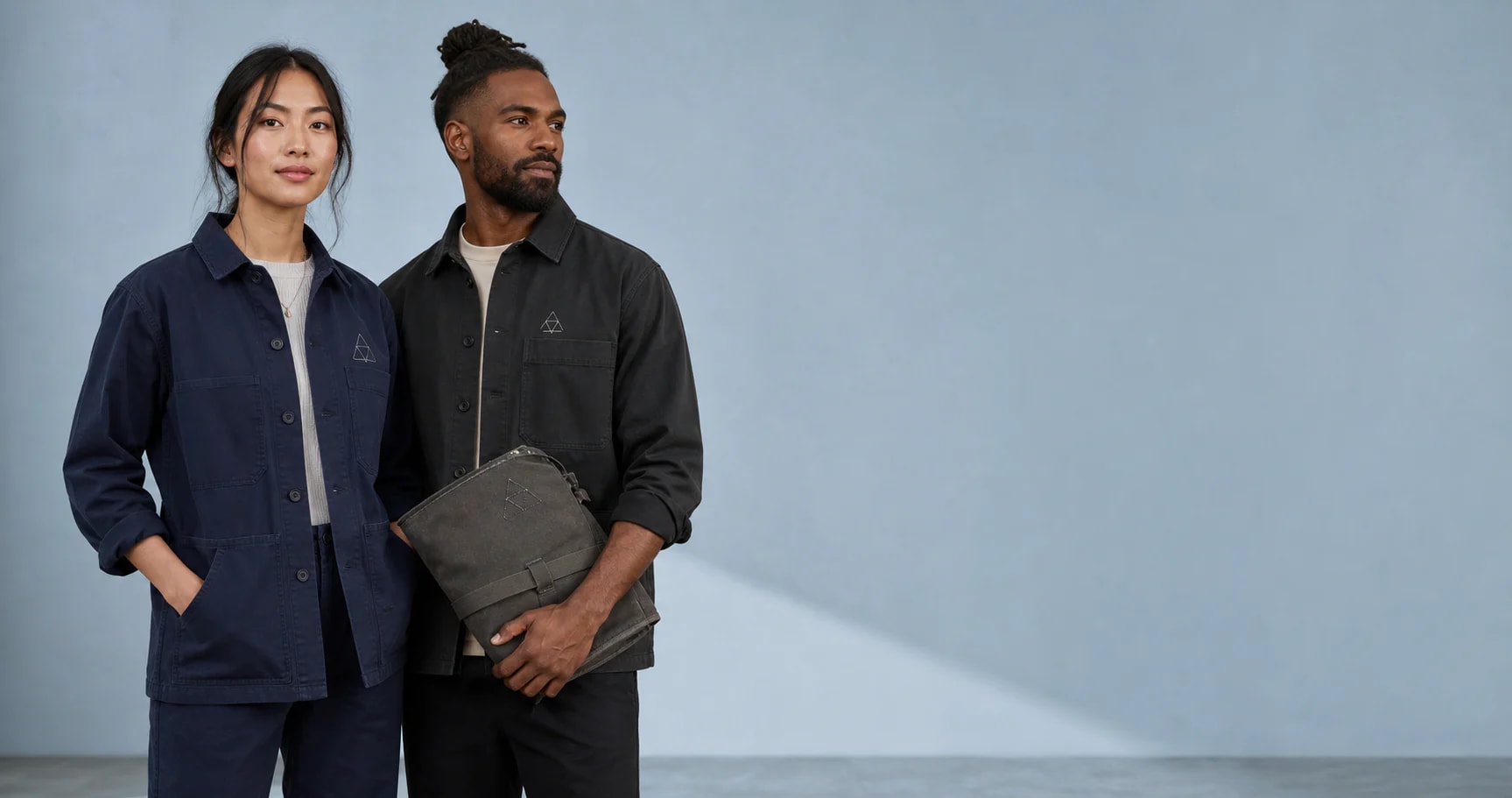 Two people in chore jackets finished with a small tonal embroidered chest monogram